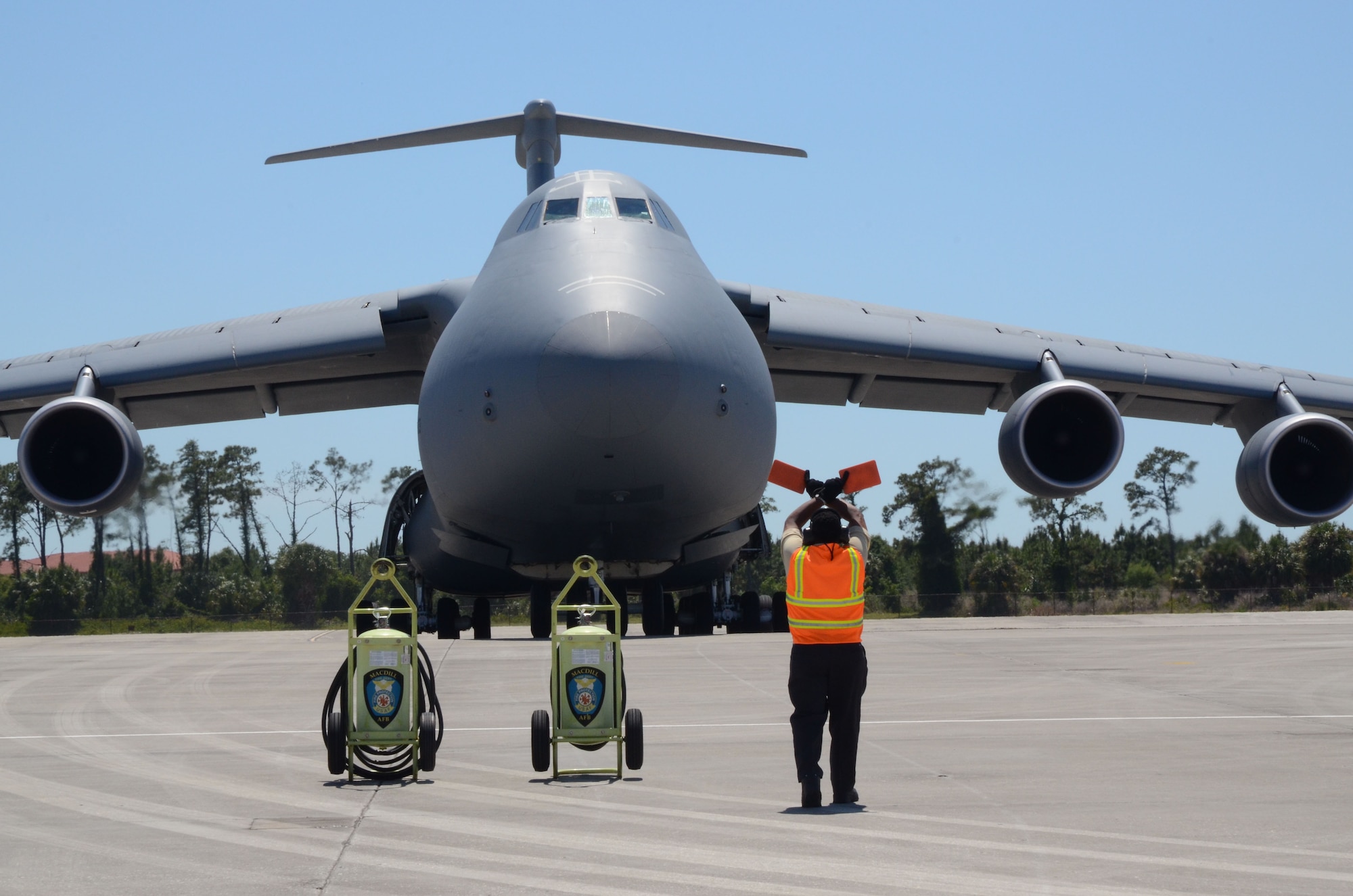 Kenneth Hudson, Transient Alert at MacDill Air Force Base, Fla., marshals a C-5M Super Galaxy to its parking spot April 27, 2012. The C-5M is from Dover Air Force Base, Del., and took part in Patriot Sands, an airlift control flight exercise done in conjunction with affiliated FBI Rapid Deployment Rapid Deployment Teams April 26-29, 2012, in Florida. (U.S. Air Force photo by Capt. Marnee A.C. Losurdo)