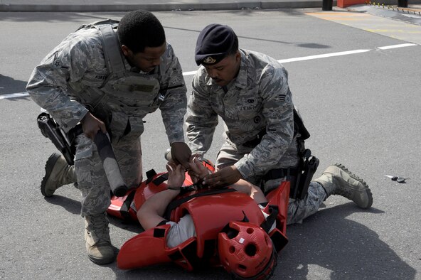 U.S. Air Force Airman Adrian Askew, left, and Senior Airman Diandre Zachary, right, 35th Security Forces Squadron patrolmen, apprehends a simulated aggressor during an operational readiness exercise at Misawa Air Base, Japan, April 28, 2012. The exercise tested the reaction and response of the 35 SFS Airmen. (U.S. Air Force photo by Tech. Sgt. Marie Brown/Released)