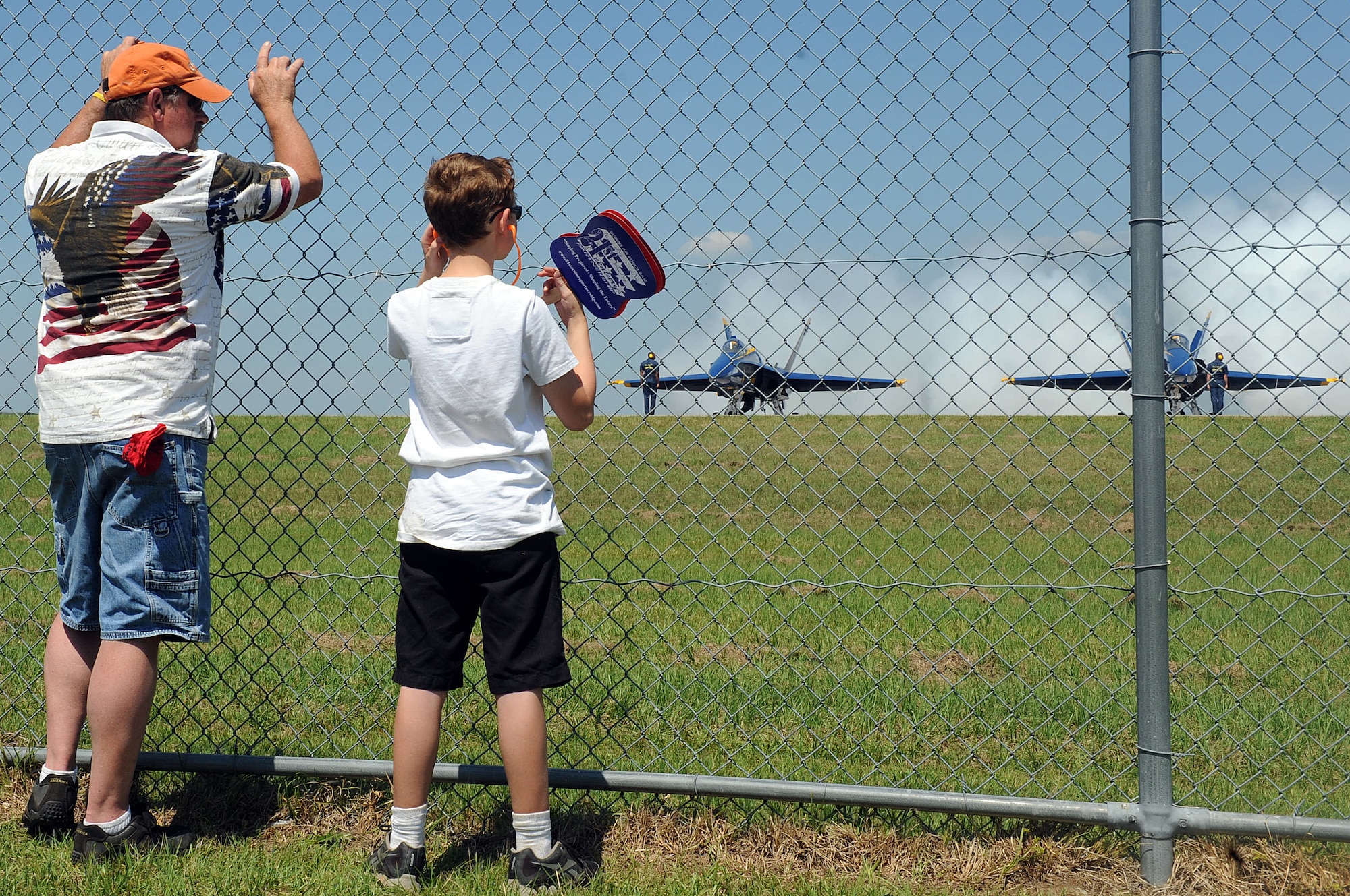 Dudley Hall and his 11-year-old son, Hunter, peer through the fence at the Blue Angels as they prepare for flight at the 2012 Robins Air Show. (U.S. Air Force photo by Tommie Horton)