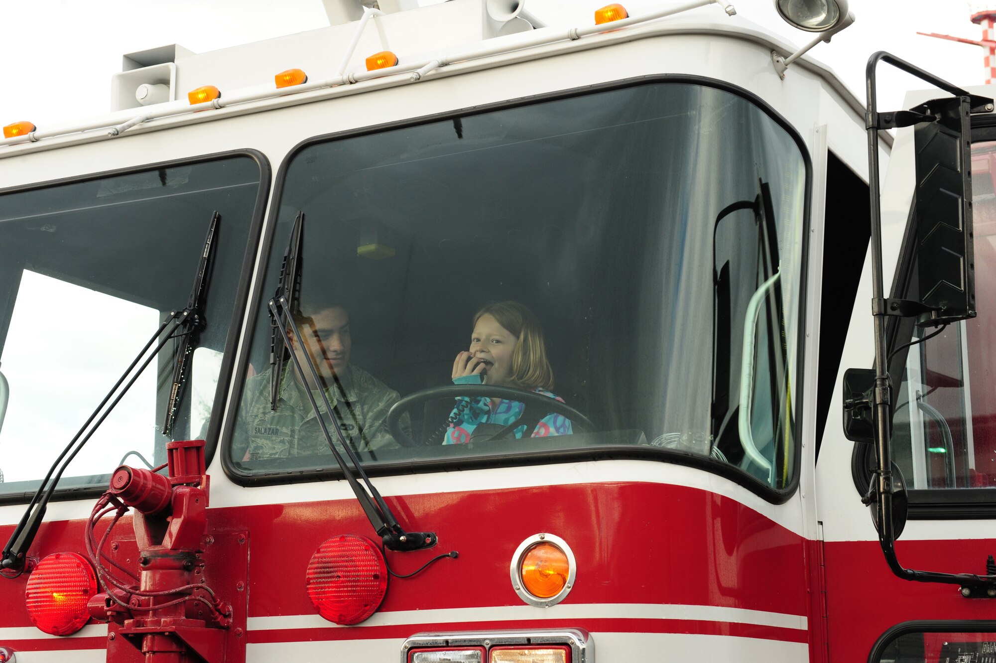 Madison Elliot, 7, daughter of Chief Master Sgt. Paul Elliot, uses the speaker on a fire truck at the 86th Vehicle Readiness Squadron on Ramstein Air Base, Germany, April 27, 2012. Job Shadow Day in the Kaiserslautern Military Community is an annual event in which children have the opportunity to shadow their sponsor or a work place mentor, completing a half-day on the job in an effort to introduce the young people the working community through participation. (U.S. Air Force photo/ Airman 1st class Kendra Alba)