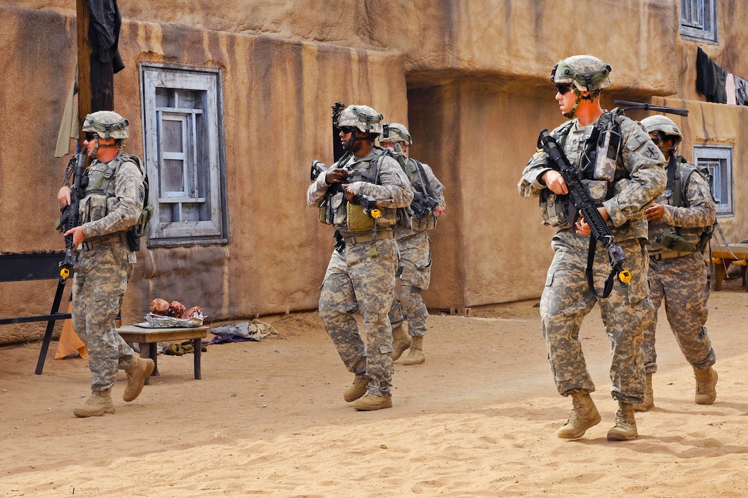 Soldiers patrol through a village during a situation training exercise ...