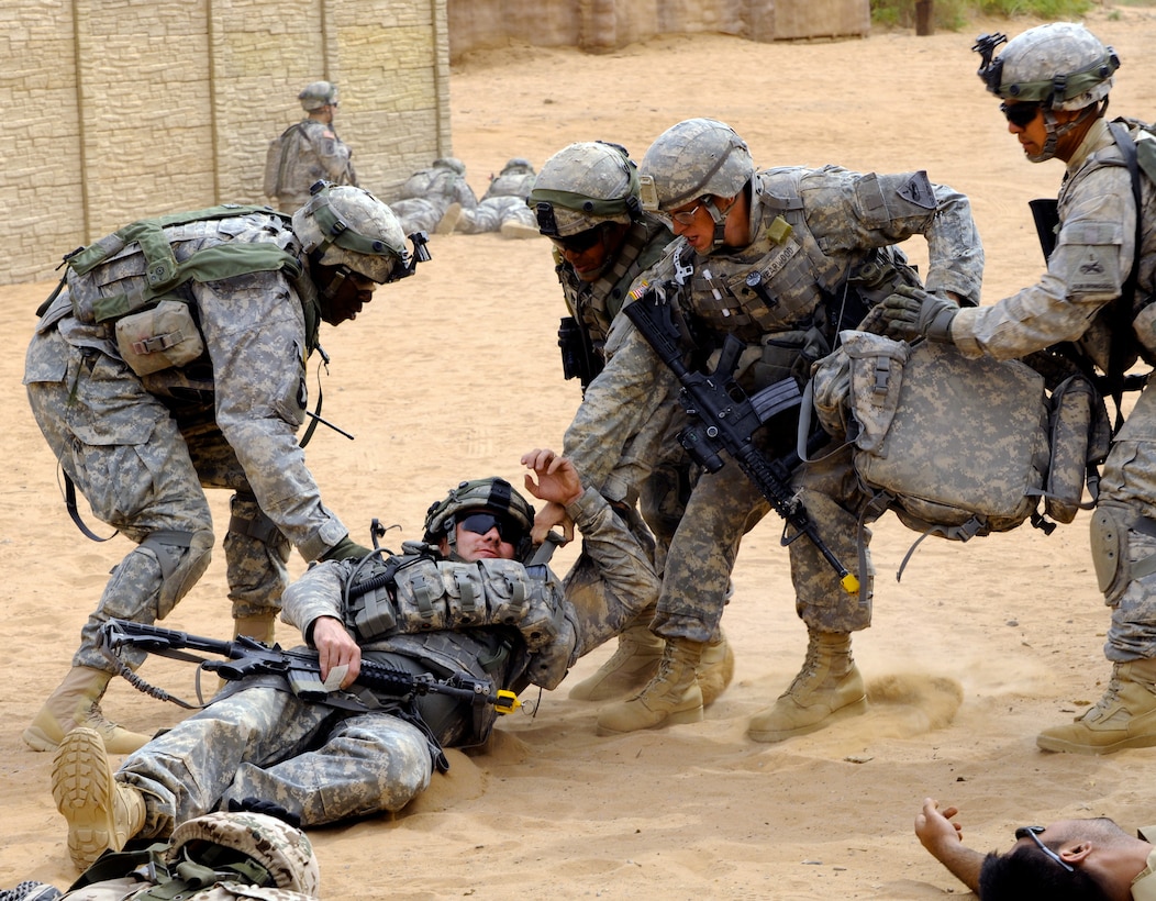 Soldiers drag a member of the civil affairs team to cover after he was wounded in a simulated suicide attack during a training exercise held at Kamal Jabour, a mock Afghan village located on a training facility on Fort Bliss, Texas, April 26, 2012.