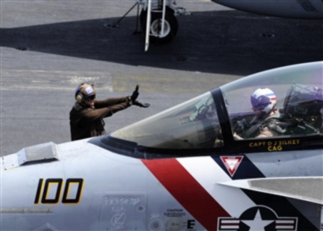 A plane captain signals to the pilot of an F/A-18F Super Hornet on the flight deck of the aircraft carrier USS Abraham Lincoln (CVN 72) as the ship conducts flight operations in the Arabian Sea on April 25, 2012.  The Nimitz class carrier is deployed to the U.S. 5th Fleet area of responsibility conducting maritime security operations, theater security cooperation efforts and support missions as part of Operation Enduring Freedom.  