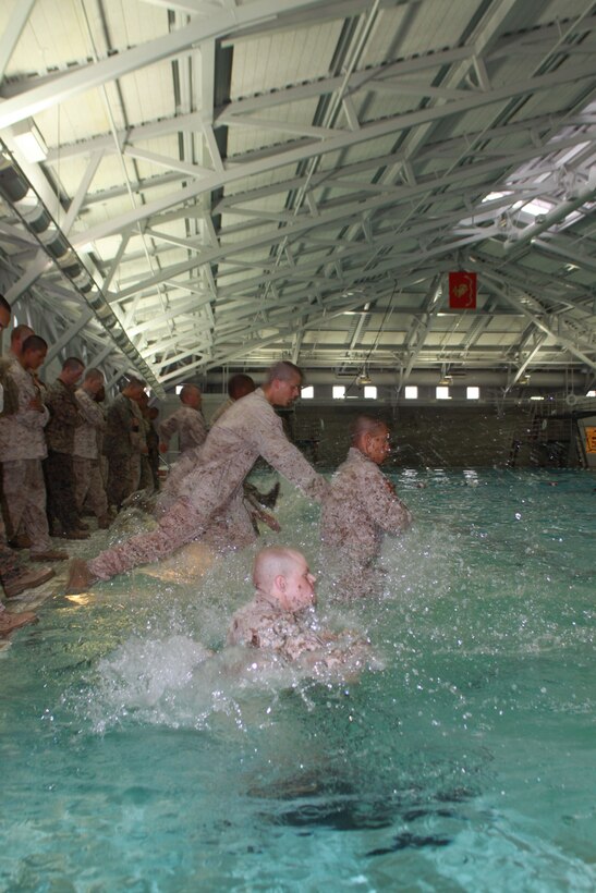 Company H recruits jump into the shallow end of the Marine Corps Recruit Depot San Diego Swim Tank April 30. Co. H started week four off with Combat Water Survival that requires them to swim in Marine pattern utilities with combat boots. They must pass multiple important water tests during this week to be able to be called a Marine.