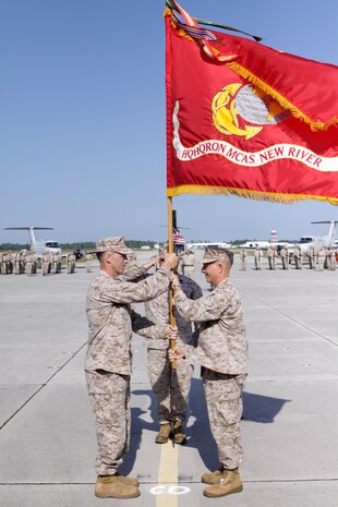 Lt. Col. Eric S. Wise, right, passes the Headquarters and Headquarters Squadron colors to Lt. Col. Walter S. Lee during the squadron’s change of command ceremony aboard Marine Corps Air Station New River, July 17.
