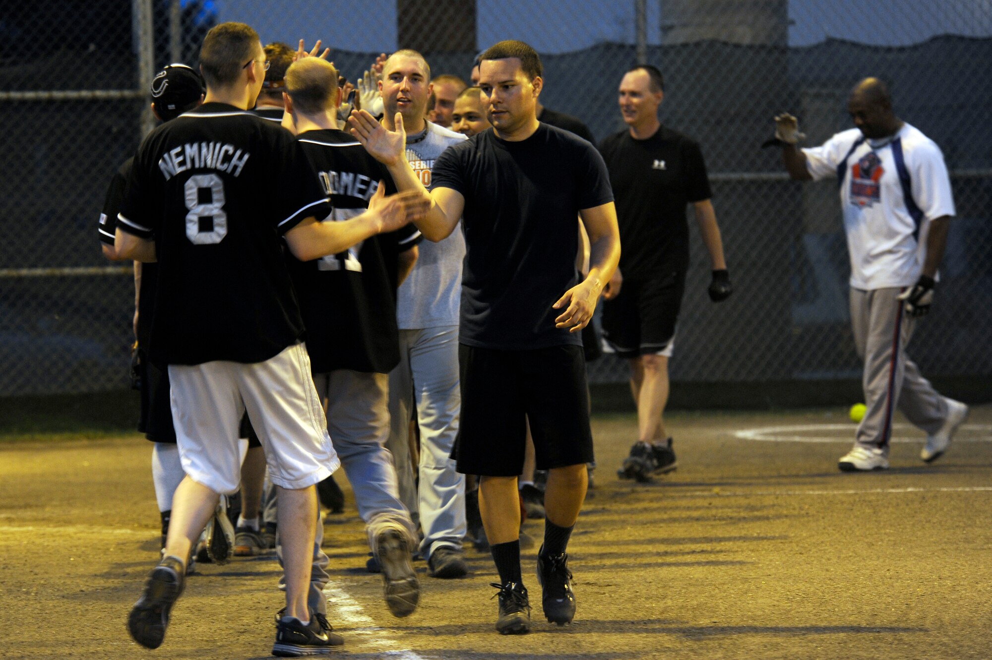 Team members for the 35th Force Support Squadron and Commander Task Force 72 congratulate each other at the end of the intramural softball championship game at Misawa Air Base, Japan, Aug. 1, 2012. CTF-72 played in the National League with a 6-3 record; they were 4th on the top five teams that qualified for the playoffs. After a seven inning stretch CTF-72 captured the base championship title. (U.S. Air Force photo by Tech. Sgt. Marie Brown)


