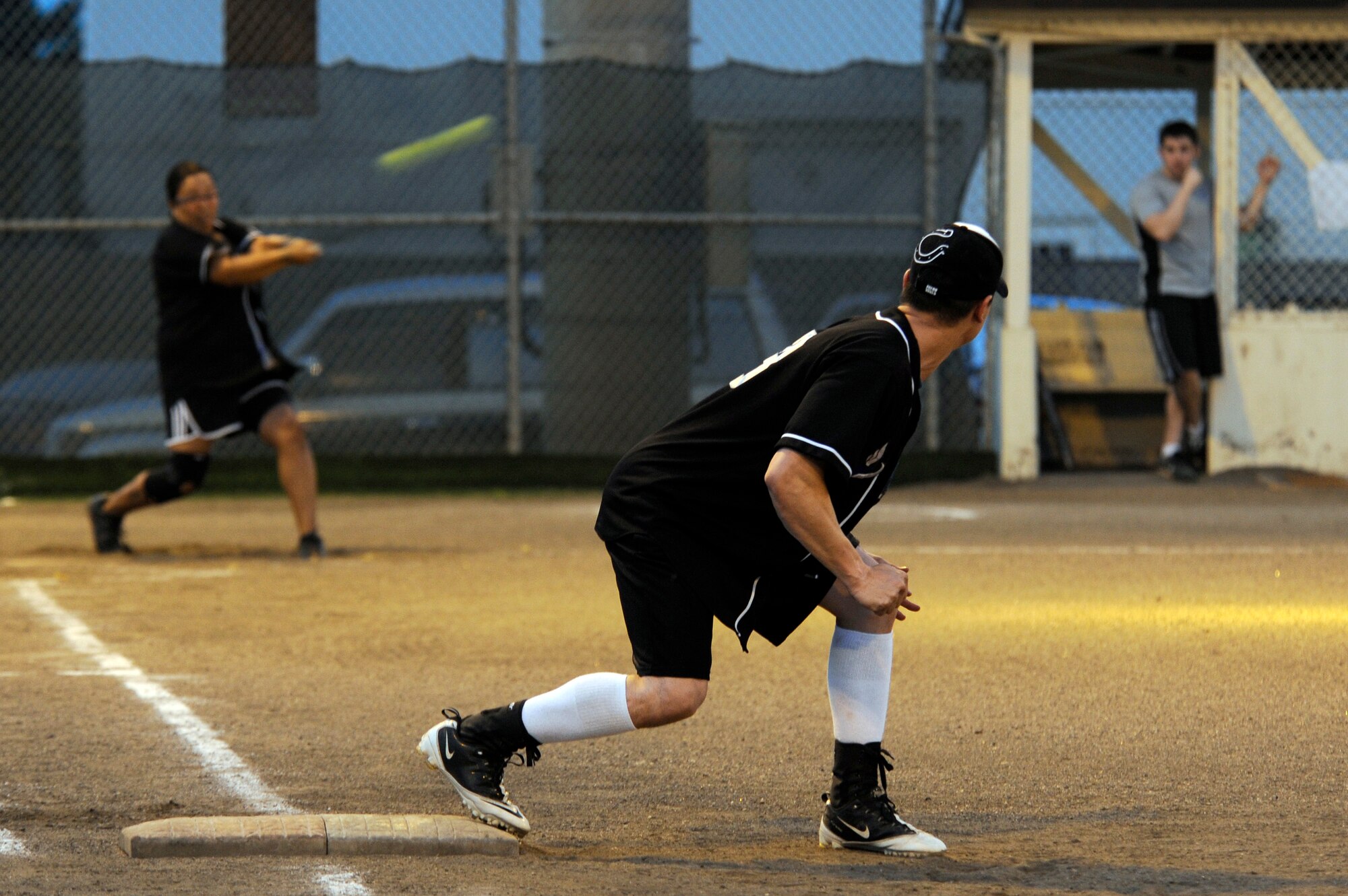 U.S. Air Force Staff Sgt. Benjamin Valenzuela, 35th Force Support Squadron, prepares to leave first base as Ms. Kim Alston, 35 FSS, hits the ball during the base intramural softball championship game at Misawa Air Base, Japan, Aug. 1, 2012. Twenty-two teams were split into two leagues, the American League and National League, that competed for the base championship with Commander Task Force 72 taking the title.  (U.S. Air Force photo by Tech. Sgt. Marie Brown)