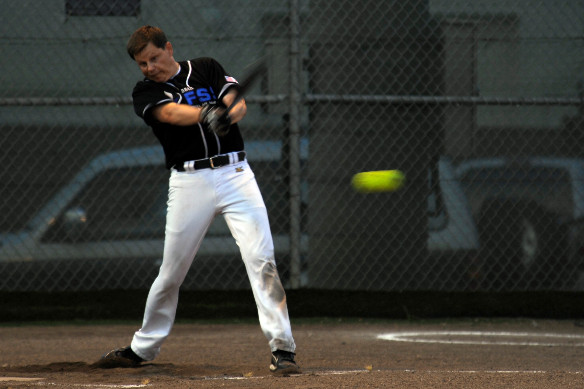 Mr. Blaine Miller, coach of the 35th Force Support Squadron team, makes contact with the ball during the intramural softball championship game at Misawa Air Base, Japan, Aug. 1, 2012. The 35 FSS lost the base championship title to Commander Task Force 72. (U.S. Air Force photo by Tech. Sgt. Marie Brown)