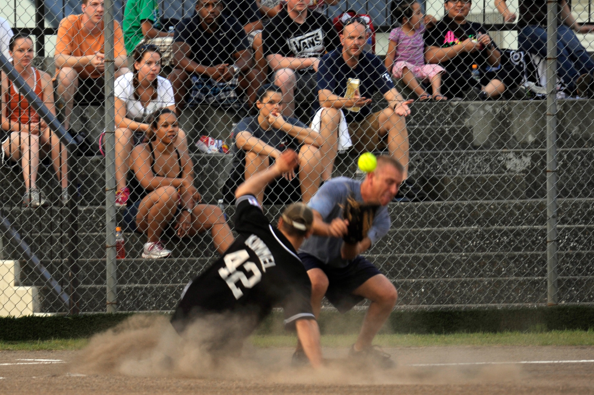 Third baseman U.S. Navy Chief Petty Officer Guy Holden, Commander Task Force 72, fumbles with the ball while dodging U.S. Air Force Airman 1st Class Denny Kimmel, 35th Force Support Squadron, as he slides into third base during the intramural softball championship game at Misawa Air Base, Japan, Aug. 1, 2012. The season began 21 May and ended 1 Aug. with CTF-72 winning the championship game. (U.S. Air Force photo by Tech. Sgt. Marie Brown)