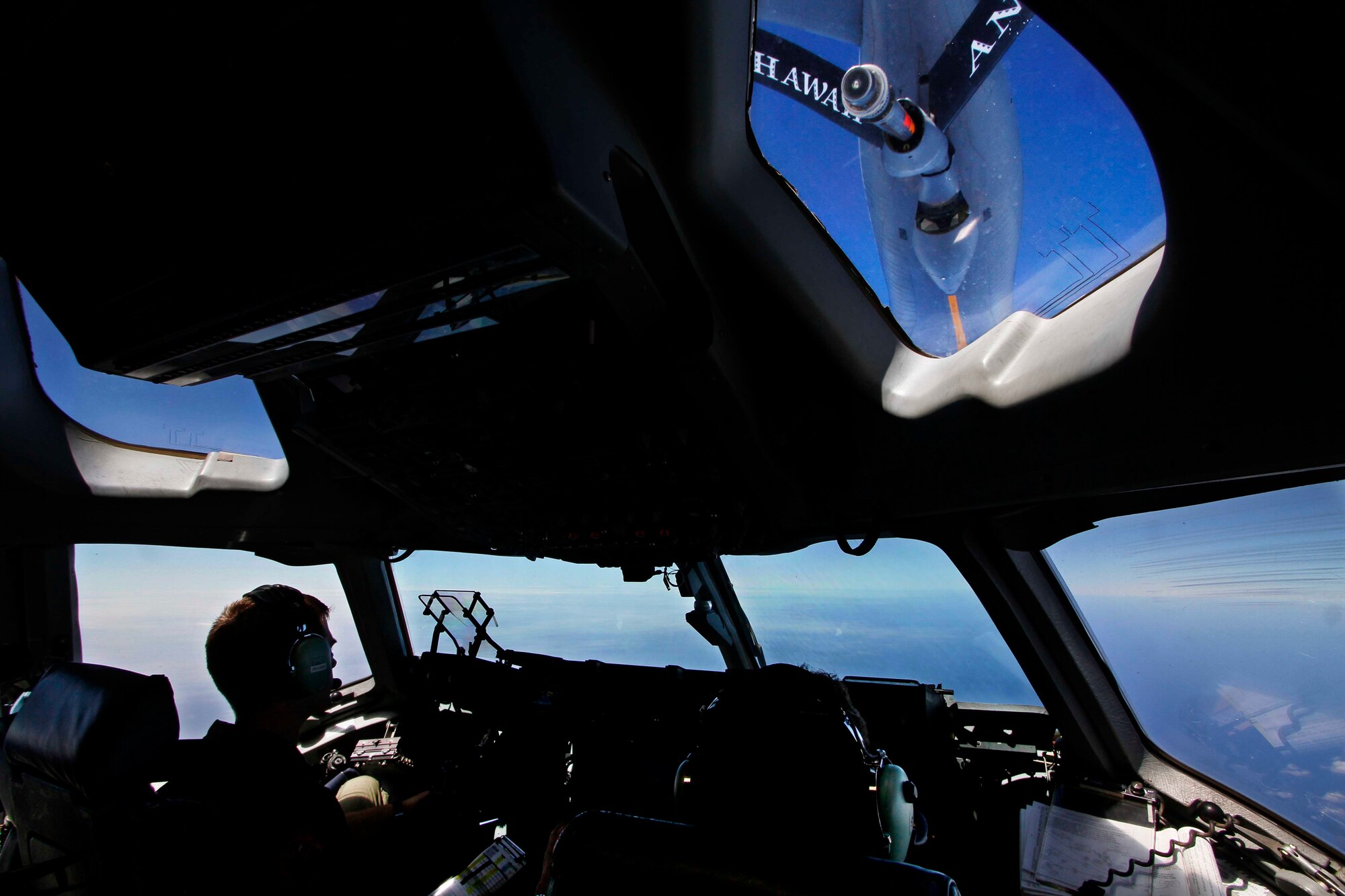 From left) Capt. Mike Recker, and Maj. Alan Partridge, C-17 Globemaster III pilots, fly as the plane is refueled by a KC-135 Stratotanker from the Air National Guard’s 203rd Air Refueling Squadron at Joint Base Pearl Harbor-Hickam, Hawaii, July 31. Along with receiving in-flight refueling, the aircrew dropped a container delivery system bundle as well as a heavy extraction platform during the flight to simulate dropping pallets of supplies to forward-deployed troops in austere locations. (Photo by Dennis Oda)