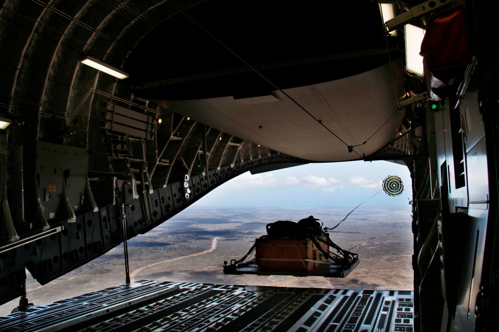 A heavy extraction platform drops out of a C-17 Globemaster III piloted by an aircrew from the 535th Airlift Squadron July 31 over the drop zone on the island of Hawaii. During the flight, the aircrew dropped a container delivery system bundle as well as a heavy extraction platform to simulate dropping pallets of supplies to forward-deployed troops in austere locations. (Photo by Dennis Oda)