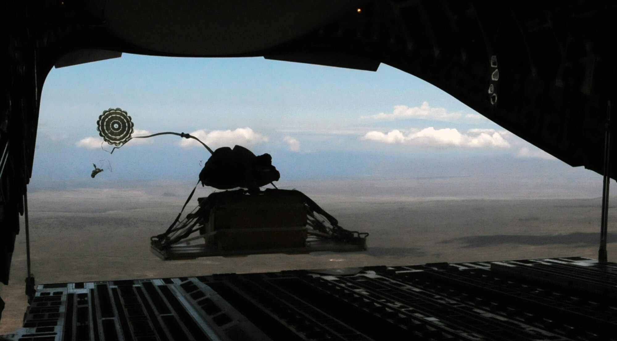 A heavy extraction platform drops out of a C-17 Globemaster III piloted by an aircrew from the 535th Airlift Squadron July 31 over the drop zone on the island of Hawaii. During the flight, the aircrew dropped a container delivery system bundle as well as a heavy extraction platform to simulate dropping pallets of supplies to forward-deployed troops in austere locations. (U.S. Air Force photo by Staff Sgt. Nathan Allen)