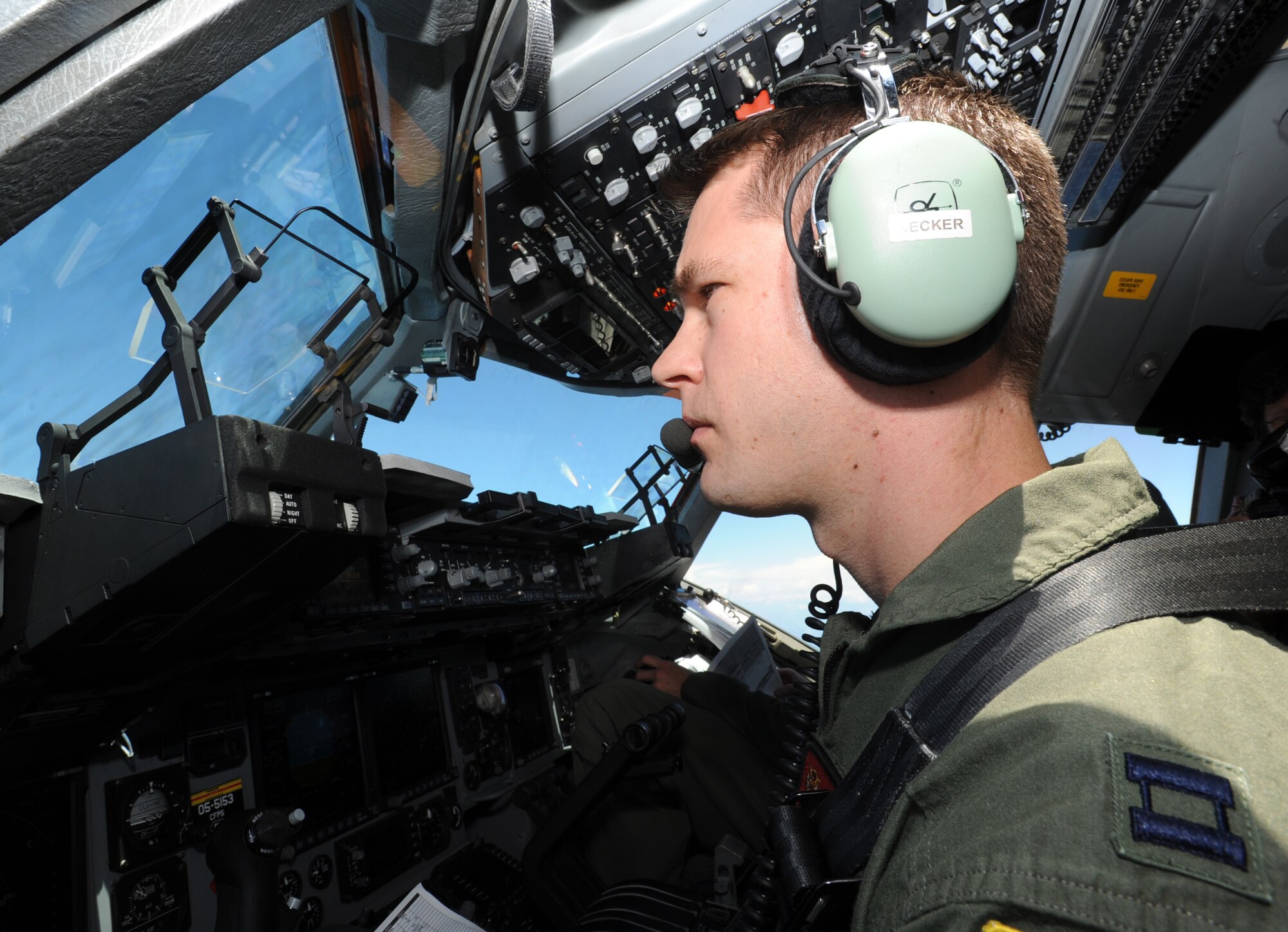 Capt. Mike Recker, 535th Airlift Squadron pilot, flies a C-17 Globemaster III over the Hawai’ian Islands July 31. During the flight, the aircrew dropped a container delivery system bundle as well as a heavy extraction platform to simulate dropping pallets of supplies to forward-deployed troops in austere locations. (U.S. Air Force photo by Staff Sgt. Nathan Allen)