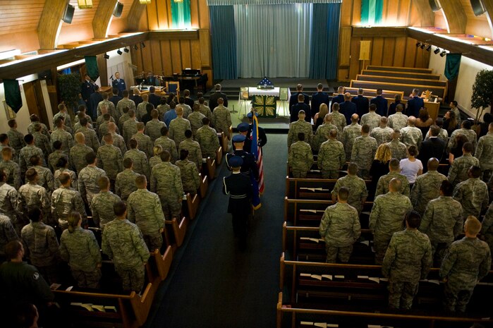 Friends and family of Senior Airman Derek Moore, 757th Aircraft Maintenance Squadron electrical and environmental systems journeyman, stand for the posting of the colors during a memorial service held for him July 27, 2012, at Nellis Air Force Base, Nev. Moore, who enlisted in the Air Force Feb. 17, 2009, was killed in a motorcycle accident July 23. He was from Bald Knob, Ark., and is survived by his mother, father and sister.(U.S. Air Force photo by Airman 1st Class Matthew Lancaster)