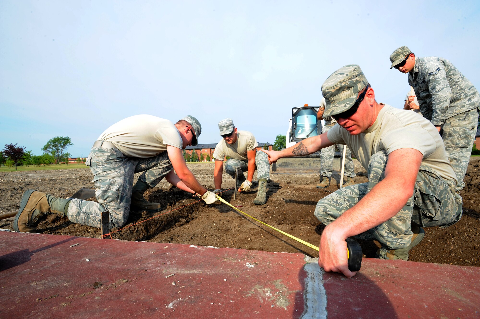 Members of the 319th Civil Engineer Squadron measure the dimensions for a concrete block on July 31, 2012, on Grand Forks Air Force Base, N.D.  The block will hold the flag pole for a new drill pad.  (U.S. Air Force photo by Airman 1st Class Xavier Navarro)