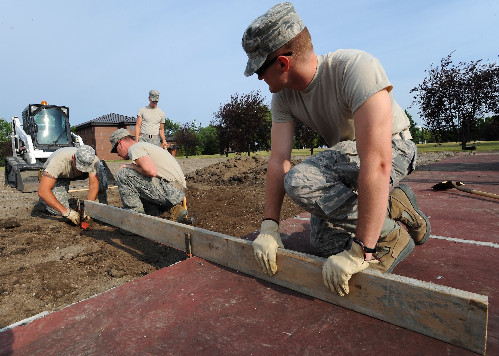 Members of the 319th Civil Engineer Squadron prepare to level an area for a concrete block on July 31, 2012, on Grand Forks Air Force Base, N.D.  The concrete block will hold a flag pole for a new drill pad.  (U.S. Air Force photo by Airman 1st Class Xavier Navarro)