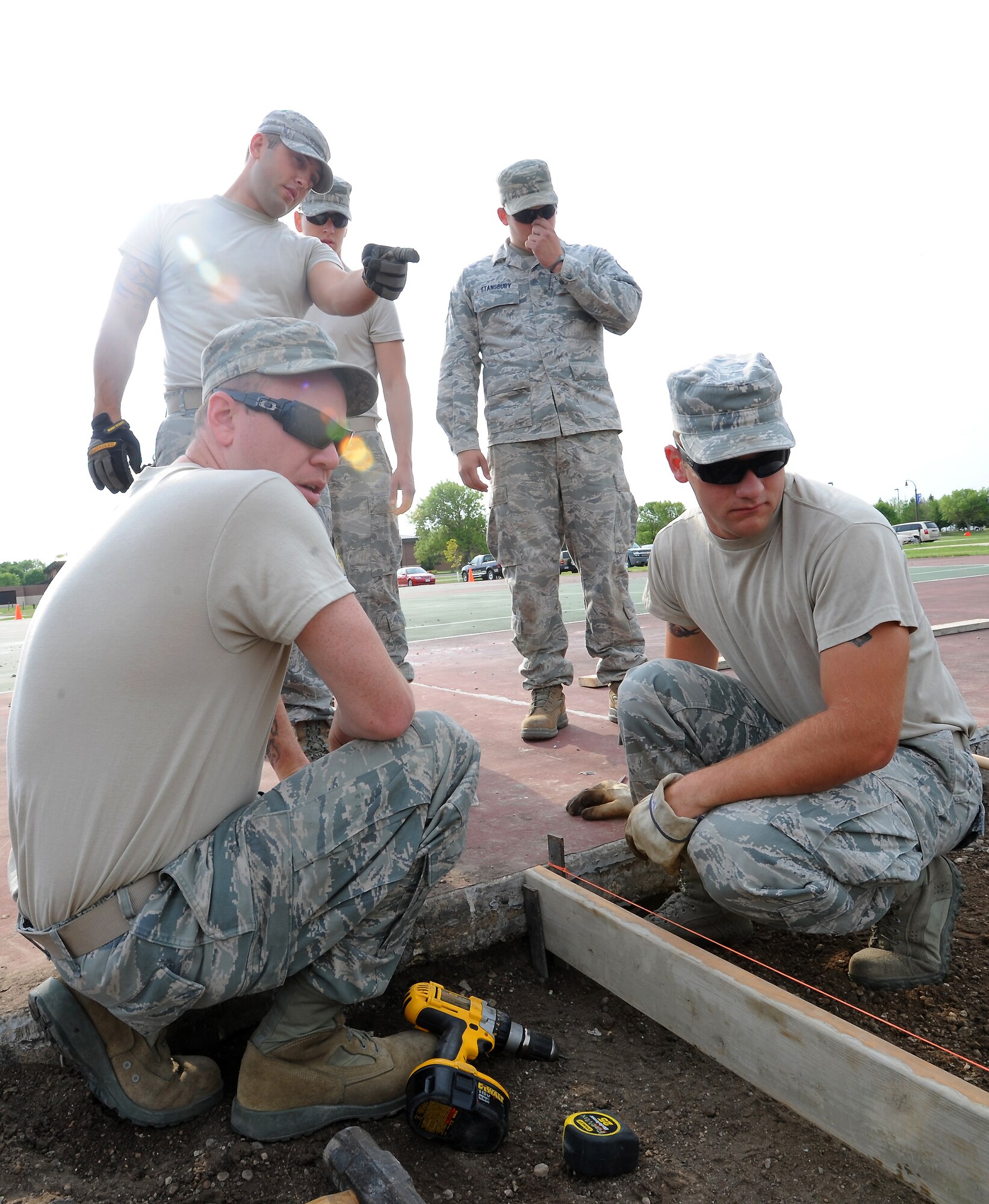 Members of the 319th Civil Engineer Squadron discuss the plans for constructing a concrete block on July 31, 2012, on Grand Forks Air Force Base, N.D.  The concrete block will hold the flag pole for a new drill pad.  (U.S. Air Force photo by Airman 1st Class Xavier Navarro)