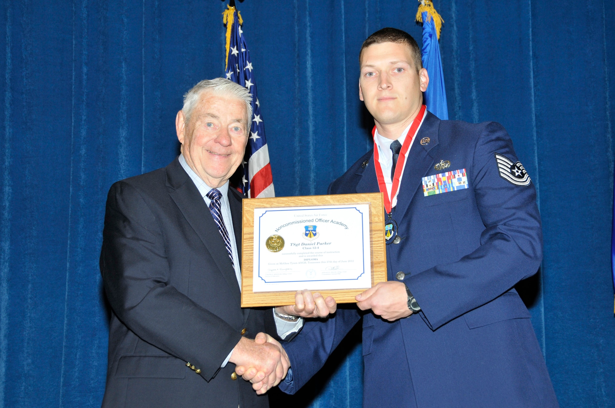 McGHEE TYSON AIR NATIONAL GUARD BASE, Tenn. - Tech. Sgt. Daniel Parker, right, receives the distinguished graduate award for Satellite NCO Academy Class 12-4 at The I.G. Brown Training and Education Center here from retired Chief Master Sgt. of the Air Force Robert Gaylor, June 27, 2012.  The distinguished graduate award is presented to students in the top ten percent of the class.  It is based on objective and performance evaluations, demonstrated leadership, and performance as a team player. (National Guard photo by Master Sgt. Kurt Skoglund/Released)