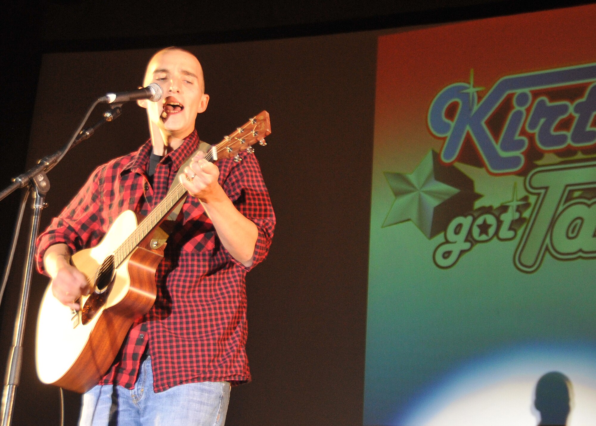KIRTLAND AFB, N.M. -- Staff Sgt. Brandon Gomez, 377th Security Forces Squadron, plays guitar and sings an original composition July 28 during the finals of “Kirtland’s Got Talent.” He was the talent contest’s grand prize winner, taking home a check for $1,000. (Photo by Todd Berenger)