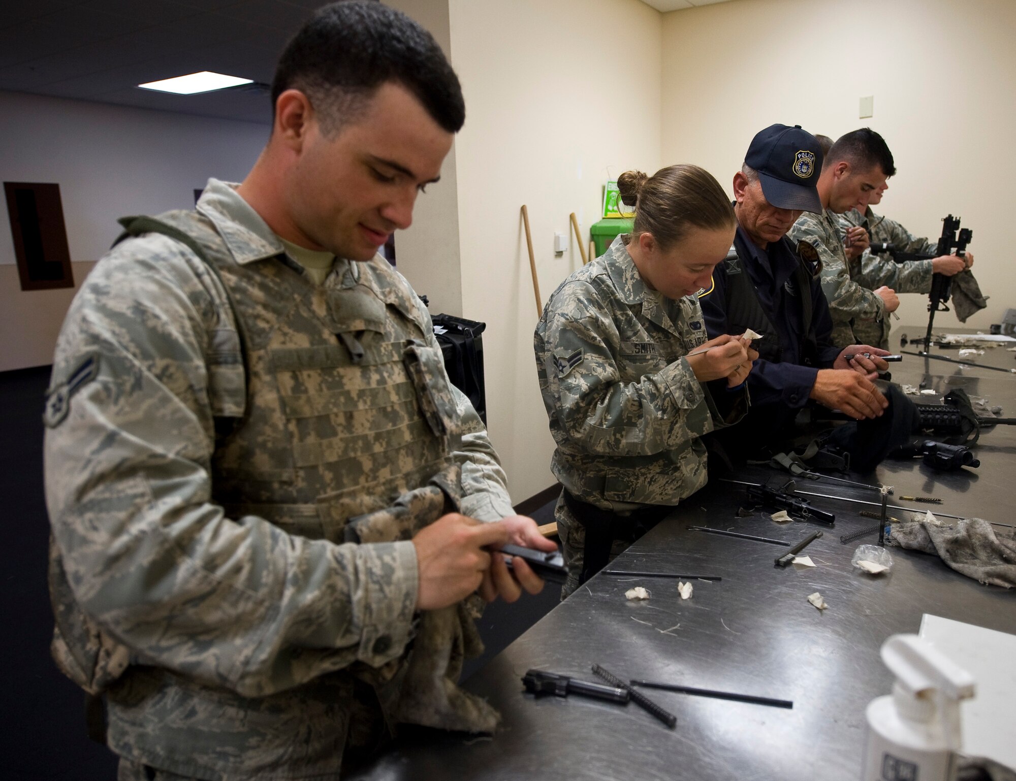 Personnel from the 2nd Security Forces Squadron clean their weapons in the 2 SFS guard mount room on Barksdale Air Force Base, La., July 31. If their weapons are due for cleaning, they must pass an inspection by the armorers before the Airman is allowed to return the weapon. (U.S. Air Force photo/Staff Sgt. Chad Warren)(RELEASED)