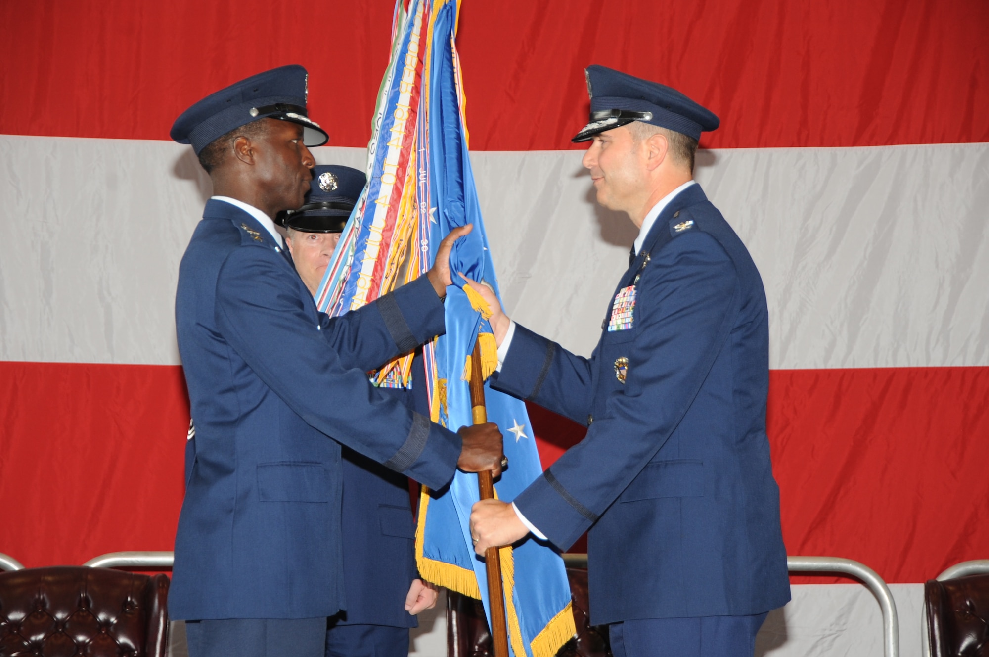 KIRTLAND AFB, N.M. -- Gen. Edward Rice Jr., Air Education and Training Command commander, left, passes the unit guidon to Col. Vincent Becklund, 58th Special Operations Wing commander, during the 58 SOW change of command ceremony July 26 at Hangar 1000. (Photo by Dennis Carlson)