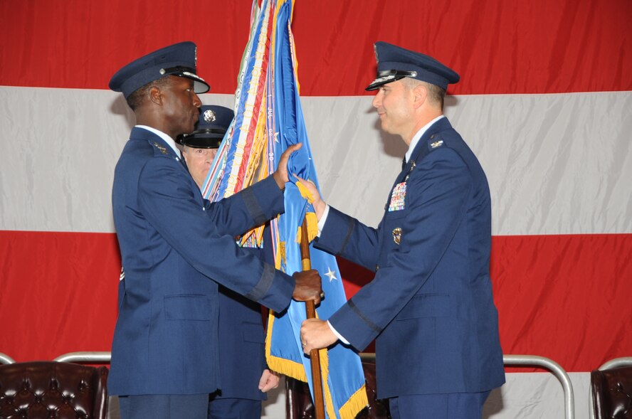 KIRTLAND AFB, N.M. -- Gen. Edward Rice Jr., Air Education and Training Command commander, left, passes the unit guidon to Col. Vincent Becklund, 58th Special Operations Wing commander, during the 58 SOW change of command ceremony July 26 at Hangar 1000. (Photo by Dennis Carlson)