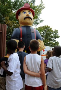 Children from Bethel Youth Services play with “Bob the Firefighter” during Operation Hero, at Langley Air Force Base, Va., Aug. 1, 2012. The Eleventh Annual Operation Hero event gave children of Airmen insight into what their parents experience during the deployment process. (U.S. Air Force photo by Airman 1st Class Teresa Cleveland/Released)