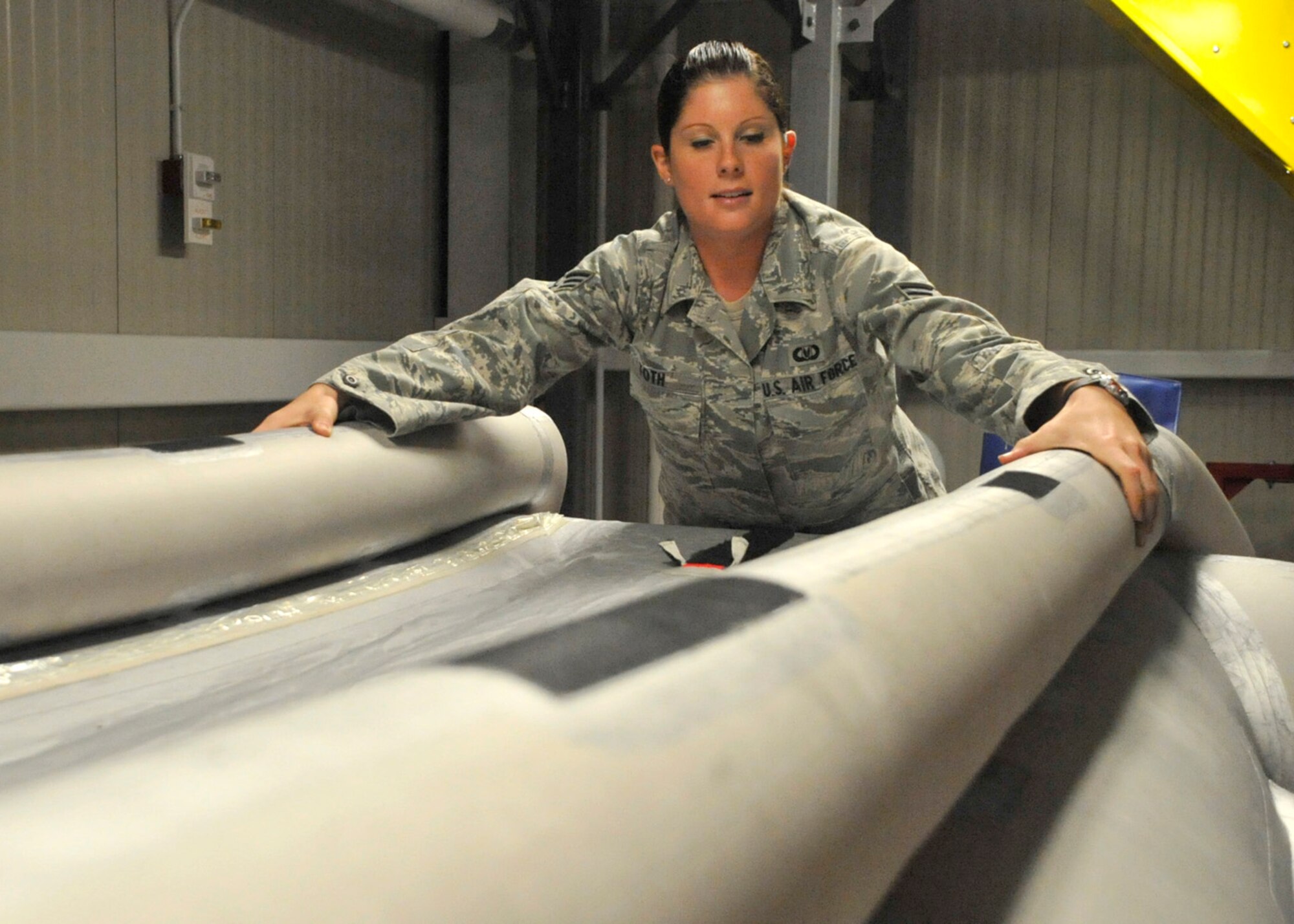 Senior Airman Brittany Toth, an aircrew flight equipment technician with the 436th Operations Support Squadron, examines an inflatable slide for air leaks Aug. 1, 2012, at Dover Air Force Base, Del. The slide can be deployed from an aircraft to enable aircrew to escape during emergencies. (U.S. Air Force photo by Tech. Sgt. Chuck Walker)