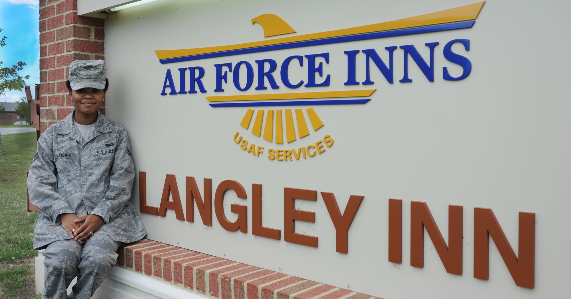 Senior Airman Dara Alexander sits in front of the Langley Inn sign, July 31, 2012, at Langley Air Force Base, Va. While not on the job, Alexander is an avid singer, often called upon to sing the national anthem at various ceremonies.  (US Air Force photo by Airman 1st Class R. Alex Durbin/Released)