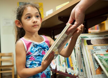Alexis Viale finds a book to read  at the summer reading program's end of year celebration July 28 at Joint Base San Antonio-Randolph, Texas. (U.S. Air Force photo by Benjamin Faske)