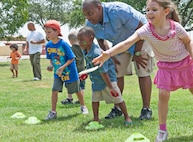 Capt. Darnell Durrah, San Antonio Military Medical Center psychology intern, watches his son Chad toss bean bags during the summer reading programs end of year celebration at Joint Base San Antonio-Randolph Texas, July 28. (U.S. Air Force photo by Benjamin Faske)