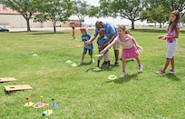 Addison Newman plays ring toss at the summer reading programs end of year celebration July 28 at Joint Base San Antonio-Randolph, Texas. (U.S. Air Force photo by Benjamin Faske)