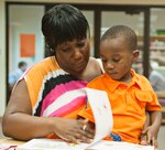 Master Sgt. Shokia Turner Intelligence Surveillance Reconnaissance  Agency career assistance adviser, reads a book to her son Ayden at the summer reading programs end of year celebration July 28 at Joint Base San Antonio-Randolph, Texas. (U.S. Air Force photo by Benjamin Faske)