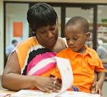 Master Sgt. Shokia Turner Intelligence Surveillance Reconnaissance  Agency career assistance adviser, reads a book to her son Ayden at the summer reading programs end of year celebration July 28 at Joint Base San Antonio-Randolph, Texas. (U.S. Air Force photo by Benjamin Faske)