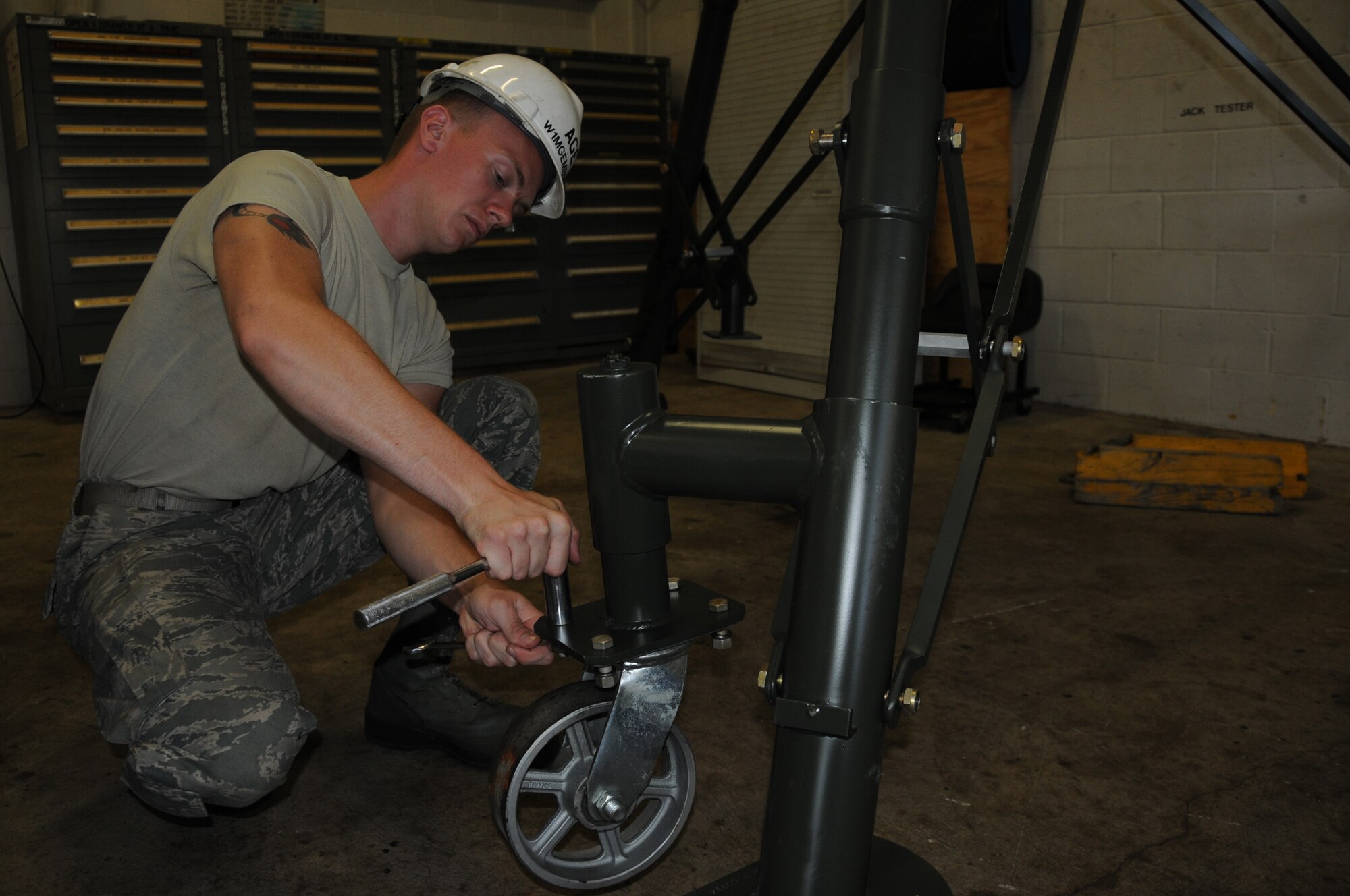 Senior Airman Bill McKenzie, a 911th Airlift Wing maintenance squadron aircraft ground equipment technician, secures a wheel to a brand new B-4A 30-ton jack, which will be used to help maintainers work on aircraft, here, July 31, 2012. In order for maintainers to repair some areas of the C-130 Hercules, it must be lifted off the ground, and it takes a total of four B-4A 30-ton jacks to lift one aircraft. (U.S. Air Force photo by Senior Airman Joshua J. Seybert/Released)