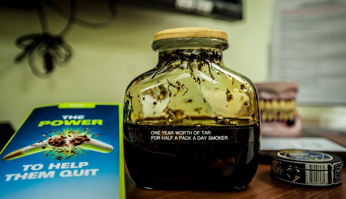 The Joint Base Charleston’s Health and Wellness Center displays a jar of tar and pamphlets near their front desk to show HAWC patrons the dangers of smoking. The HAWC’s mission is to cultivate a fit and healthy force. They achieve this through classes and services such as nutritional, exercise, tobacco cessation as well as wellness and relaxation. (U.S. Air Force photo by Senior Airman Dennis Sloan/Released)