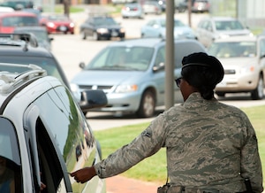 U.S. Air Force Airman 1st Class Candace Lowe, 633rd Security Forces Squadron installation entry controller, provides security at Langley Air Force Base, Va., Aug. 1, 2012. Security personnel actively check incoming vehicles for outstanding warrants, and sometimes refer the drivers to local law enforcement. (U.S. Air Force photo by Tech. Sgt. Barry Loo/Released)