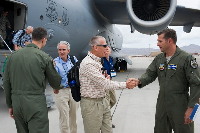 U.S. Air Force Col. Barry Cornish, 99th Air Base Wing commander, and Col. Alex Grynkewich, 57th Wing vice commander, greet distinguished visitors with Joint Civilian Orientation Conference July 23, 2012, at Nellis Air Force Base, Nev. The JCOC is a program sponsored by the Secretary of Defense for civilian public opinion leaders interested in growing their knowledge of the military and national defense issues. (U.S. Air Force photo by Airman 1st Class Christopher Tam)