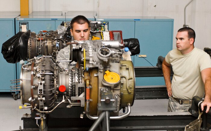 Airman 1st Class Dan Baldridge(left)823rd Maintenance Squadron aerospace propulsion technician reparis a HH-60 Pave Hawk helicopter engine while Staff Sgt. Josh Shaw(right) 823rd Maintenance Squadron aerospace propulsion technician, monitors his progress. The 823rd Maintenance Squadron is the only Air Force engine repair squadron that requires technicians to work back shop, flight line and phase repair shifts. (U.S. Air Force photo by Senior Airman Jack Sanders)