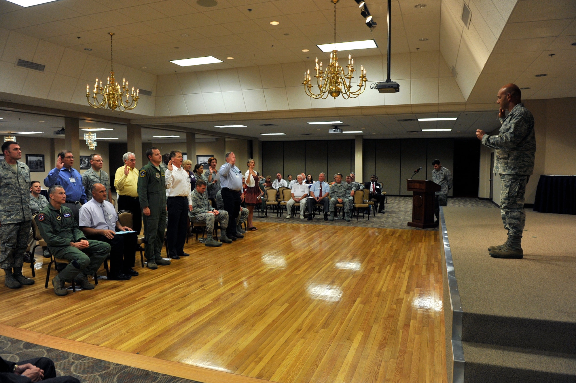 Col. Brian Robinson, 19th Airlift Wing commander, administers the oath for honorary commanders to the new 19th AW honorary commanders, during the Honorary Commanders Induction Ceremony July 31, 2012, at Little Rock Air Force Base, Ark. More than 30 Honorary Commanders attended the ceremony where eight honorary commanders were inducted. (U.S. Air Force photo by Airman 1st Class Rusty Frank)