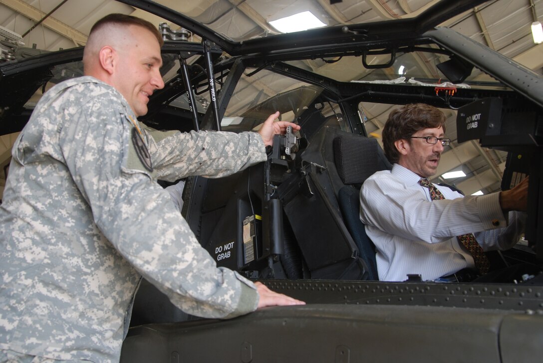 U.S. Army Sgt. 1st Class Ron Bolinsky, (left) committee chief in charge of Initial Entry Training students, 128th Aviation Brigade, Fort Eustis, Va., explains the process of what it takes to operate an AH-64D Apache Longbow helicopter at a Felker Army Airfield hangar to Trent Di Giulio, Defense Orientation Conference Association member, during DOCA's visit to Training and Doctrine Command July 30 at Fort Eustis, Va. (US Army photo by Sgt. 1st Class Kelly Jo Bridgwater/Released)