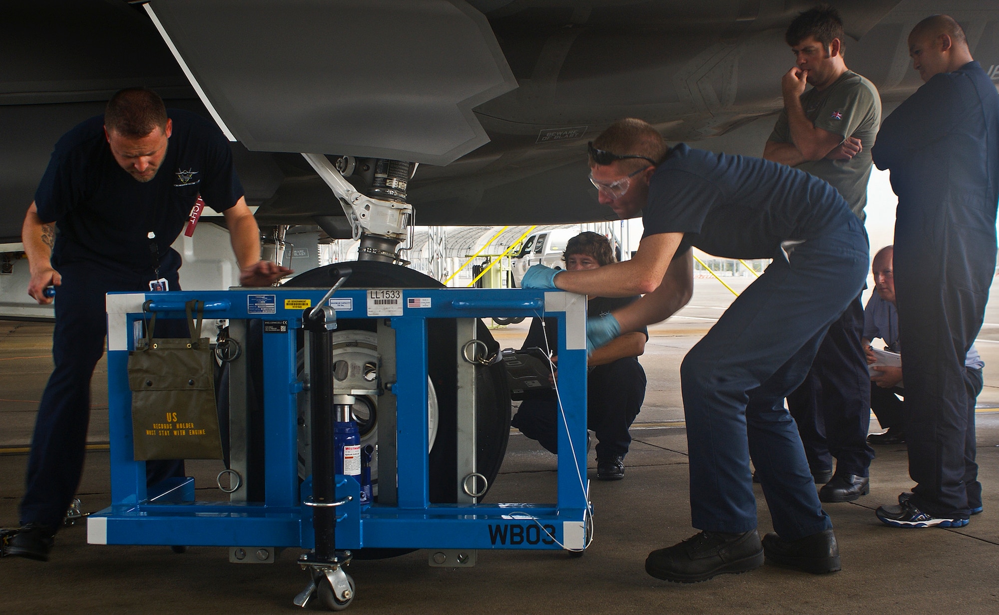British Royal Navy maintainers, Petty Officer Mike Elland and Chief Petty Officer Yuki Ho, watch a wheel and tire removal and installation demonstration as part of their F-35 maintenance training July 26 at Eglin Air Force Base, Fla.  The maintainers are here receiving maintenance training for the UK variant of the F-35.  (Courtesy photo/Gunnery Sgt. Stacey-Ann Viner)
