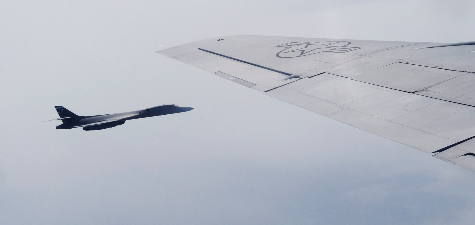 ENGLAND -- A B-1B Lancer from the 7th Bomb Wing, Dyess Air Force Base, Texas, sit at the tip of the wing of a KC-135 Stratotanker assigned to the 100th Air Refueling Wing July 31, 2012. The platform has global reach capability and can deliver up to a 75,000 pound payload. (U.S. Air Force photo/Senior Airman Ethan Morgan)