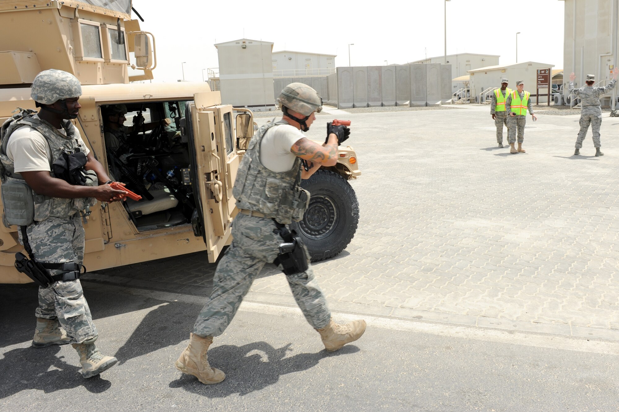 SOUTHWEST ASIA - 380th Expeditionary Security Forces Squadron Quick Response Force members move in to take down an active shooter as members of the 380th ESFS Exercise Evaluation Team look on July 31, 2012. Exercise evaluation teams observe exercise situations and provide participants with feedback on how to improve responses to similar situations. (U.S. Air Force photo/Master Sgt. Scott MacKay)