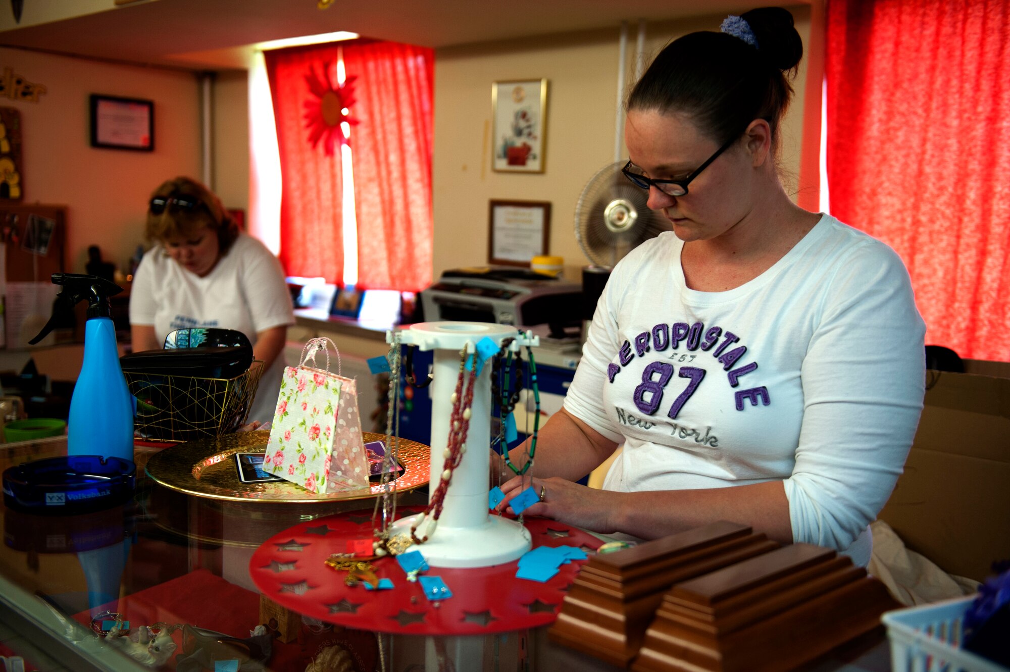 SPANGDAHLEM AIR BASE, Germany – Brinne Lueckert, left, manager, and Sara McCoy, assistant manager, of the Spangdahlem Spouses and Enlisted Member’s Club thrift shop, sort through and price donations here July 31.  All of the profits earned by the thrift shop are returned to the community through the spouse’s club. The shop is open 11 a.m. - 5 p.m. Tuesday through Thursday and the last Saturday of each month. For more information, call DSN 452-2243 or 06565-61-2243. (U.S. Air Force photo by Airman 1st Class Gustavo Castillo/Released)