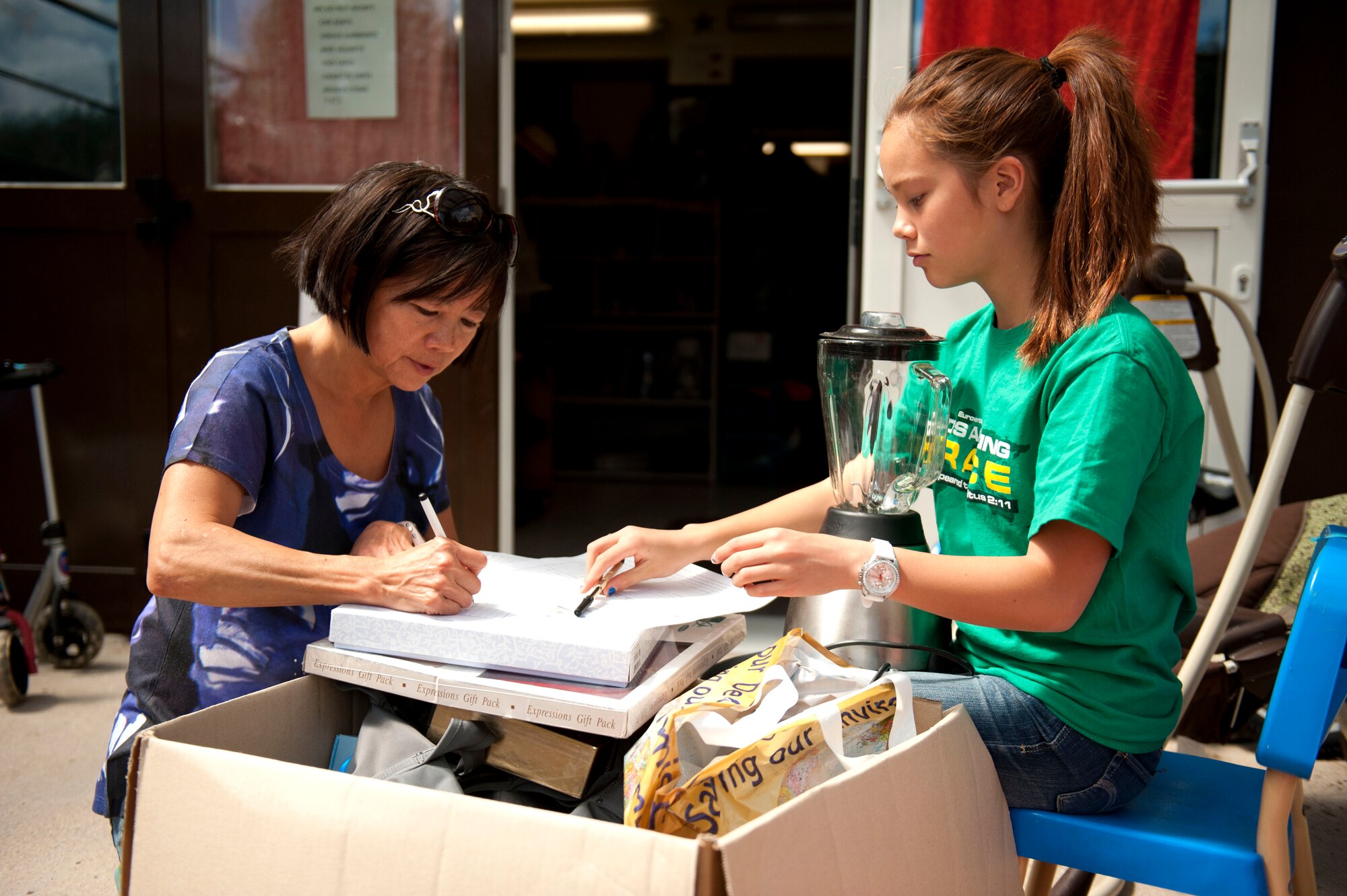 SPANGDAHLEM AIR BASE, Germany – Jaenan, left, and Allyson Kautheim sort through items intended for donation at the Spangdahlem Spouses and Enlisted Member’s Club thrift shop here July 31.  All of the profits earned by the thrift shop are returned to the community through the spouse’s club. The shop is open 11 a.m. - 5 p.m. Tuesday through Thursday and the last Saturday of each month. For more information, call DSN 452-2243 or 06565-61-2243. (U.S. Air Force photo by Airman 1st Class Gustavo Castillo/Released)