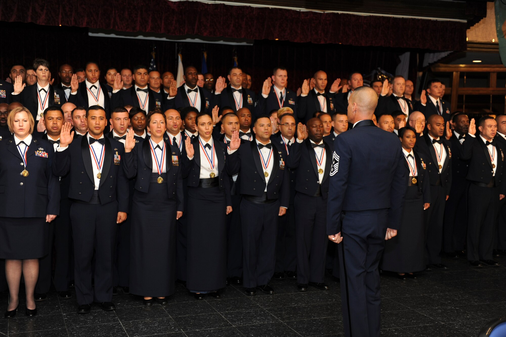 U.S. Air Force Chief Master Sgt. Mark Marson, 18th Wing command chief, charges Airmen with the duties of a senior NCO during the senior
NCO induction ceremony at Kadena Air Base, Japan, July 28, 2012. The
ceremony celebrates those who are putting on the rank of master sergeant.
(U.S. Air Force photo/Airman 1st Class Brooke P. Beers) 
