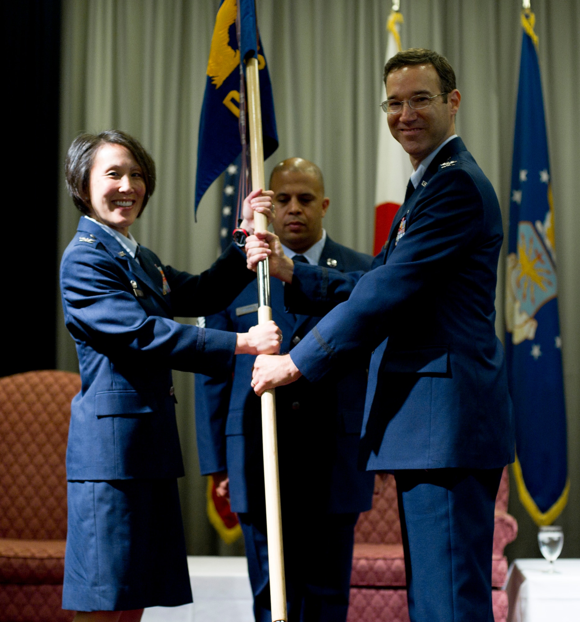 YOKOTA AIR BASE, Japan -- Col. Eveline Yao, commander of the 374th Medical Group, passes the unit guidon to Col. Daniel Savett during the 374 Dental Squadron change of command at Yokota Air Base, Japan, July 27, 2012. The passing of the guidon to the new commander signifies the start of the new command.  (U.S. Air Force photo by Staff Sgt. Stacy Moless)