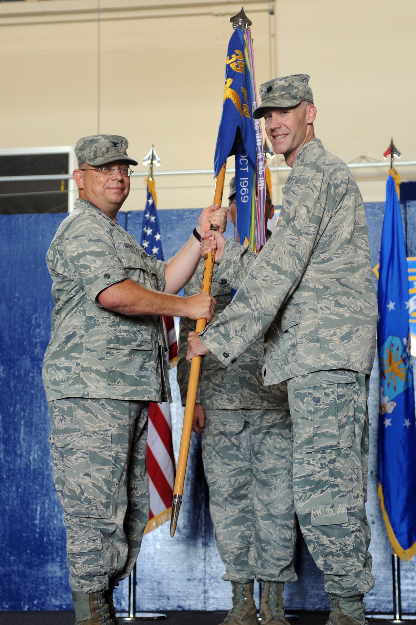 U.S. Air Force Col. Michael Griffin, left, 35th Mission Support Group commander, passes the guidon to Lt. Col. Robert Grainger, 35th Civil Engineer Squadron commander, during a change of command ceremony at Misawa Air Base, Japan, Aug. 1, 2012. The guidon symbolizes the relinquishment of command from the outgoing commander to the incoming commander. Grainger is assuming command of the 35 CES from Lt. Col. Dwayne Robison. (U.S. Air Force photo by Airman 1st Class Kia Atkins/Released)