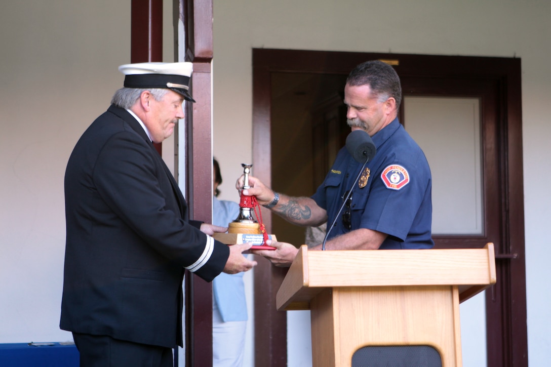 Thomas Thompson, right, the fire chief with Fire and Emergency Division, Security Battalion, awards Capt. Patrick D. Williams of Fire Station 7 in San Onofre, the Fire Officer of the Quarter award at the Camp Pendleton's Fire Department 70th Anniversary Celebration at the ranch house, Aug. 1. The celebration also held the opening of the fire exhibit at the ranch house in honor of the fire fighters 70 years of dedication and service. "It is really nice to be recognized for my accomplishments and receive these awards in front of all my peers," said Williams. "I am proud of those 30 years I have served."